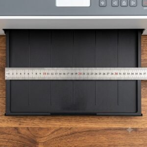 A3 DTF L18050 Printer with Module โ Powerful & Compact DTF Printing Machine | ProlificGeeks - Close-up of a stainless steel ruler measuring the 30 cm width of a desktop DTF printer output tray on a wooden desk.