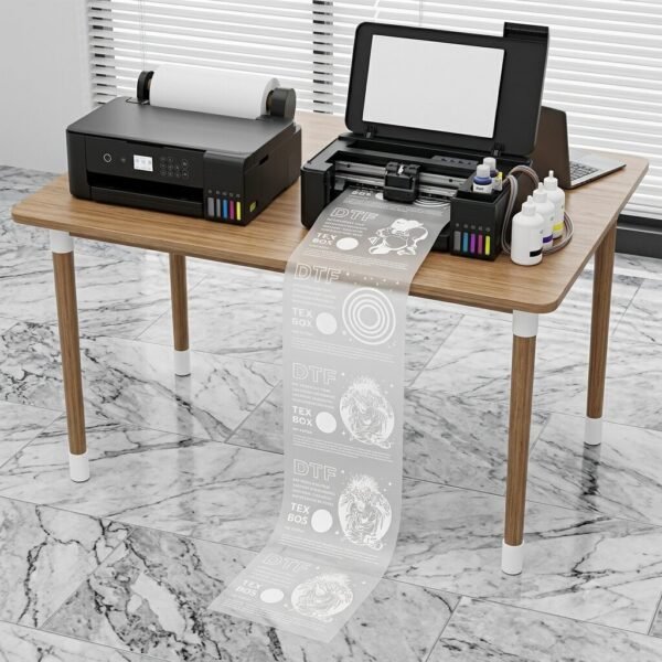 A3 DTF L18050 Printer with Module โ Powerful & Compact DTF Printing Machine | ProlificGeeks - DTF transfer printer actively printing a long continuous roll of white ink designs onto PET film onto the tiled floor in a workshop setting.